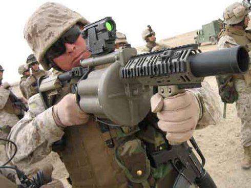 身着制式沙漠作战服、防弹背心、手持半自动榴弹发射器的美军士兵
