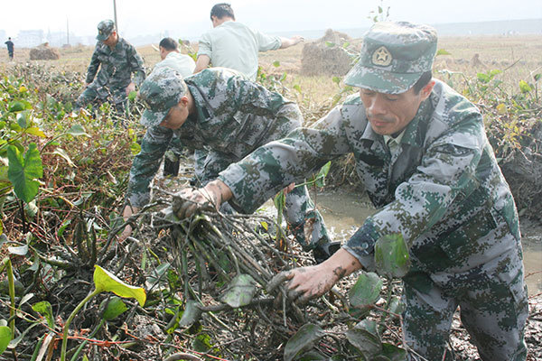 市人武部组织干部职工为贫困村清理农田飌溉水渠。