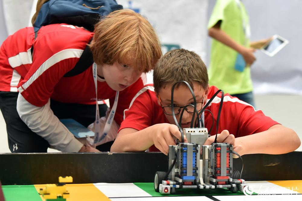 8月23日，参赛的外国选手正在调试机器人，准备比赛。（人民网记者 翁奇羽摄）
