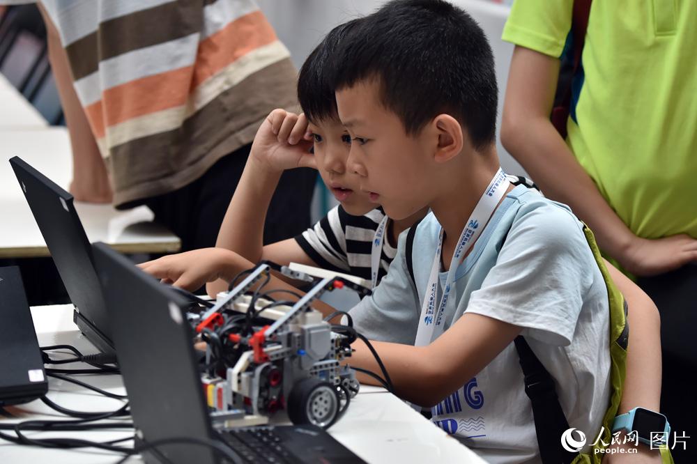 8月23日，参赛选手正在调试机器人，准备比赛。（人民网记者 翁奇羽摄）