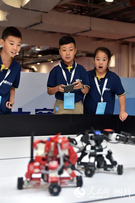 8月23日，参赛选手正在调试格斗机器人，准备比赛。（人民网记者 翁奇羽摄）
